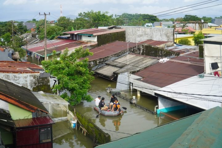 Warga di Blok 8, Perumnas Antang, Kecamatan Manggala, memakai perahu karet menyusuri genangan banjir/Muh. Syawal - Bollo.id