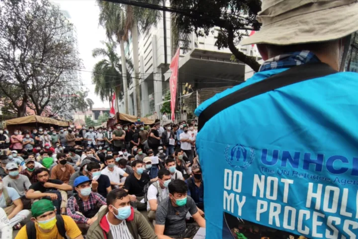 Para pengungsi dari Afghanistan menyampaikan suara mereka sementara polisi mengawasi mereka di depan kantor UNHCR, Jakarta, 24 Agustus 2021. (Foto: VOA/Indra Yoga)